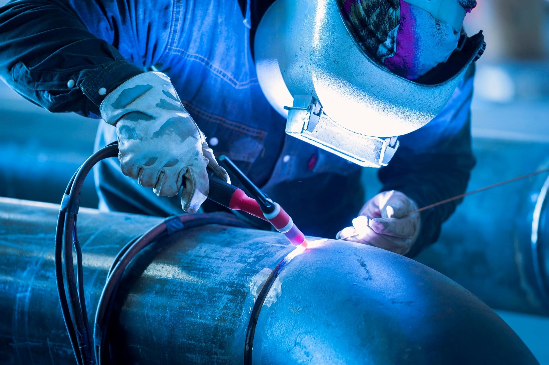 Welder performing arc welding with blue light